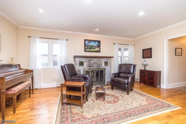 sitting room with light hardwood / wood-style flooring, crown molding, and a fireplace