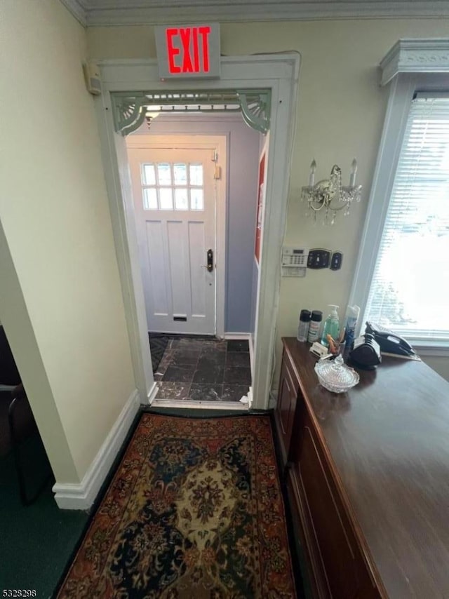 doorway to outside with ornamental molding