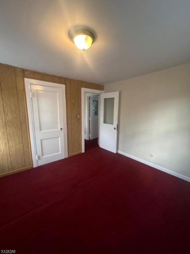 unfurnished bedroom featuring wood walls