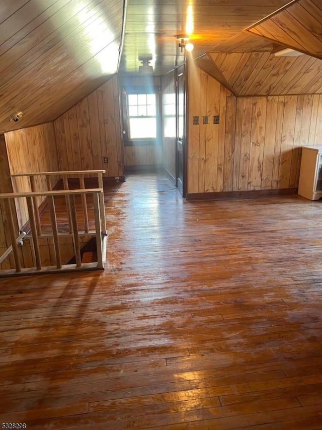 additional living space with vaulted ceiling, dark hardwood / wood-style floors, wooden ceiling, and wood walls