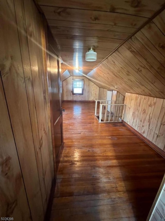 additional living space featuring lofted ceiling, wood ceiling, hardwood / wood-style flooring, and wood walls