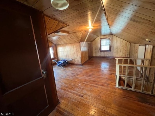 additional living space featuring wood ceiling, hardwood / wood-style flooring, vaulted ceiling, and wooden walls