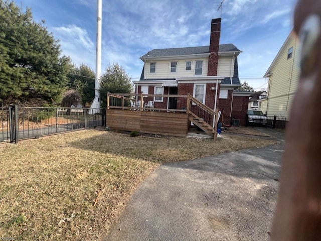 rear view of house with a yard and a deck