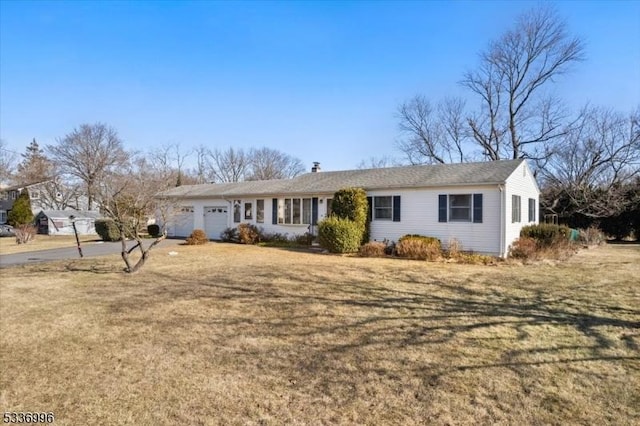 ranch-style house featuring a garage and a front lawn