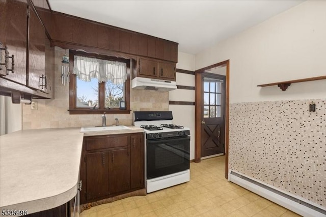 kitchen with a healthy amount of sunlight, a baseboard radiator, sink, white gas range oven, and dark brown cabinets