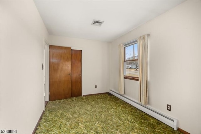 unfurnished room featuring carpet and baseboard heating