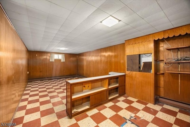 basement with baseboard heating and wooden walls