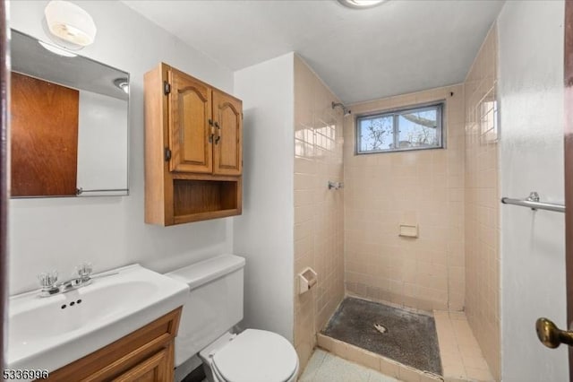 bathroom featuring vanity, tiled shower, and toilet