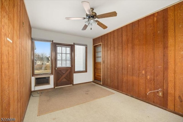 interior space featuring ceiling fan, a wall mounted air conditioner, and wooden walls