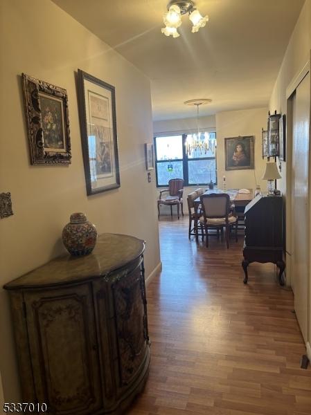 hallway featuring a notable chandelier and hardwood / wood-style flooring