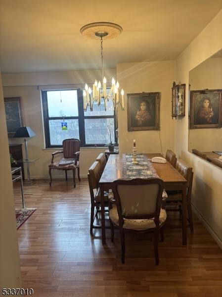 dining area featuring hardwood / wood-style flooring and a chandelier