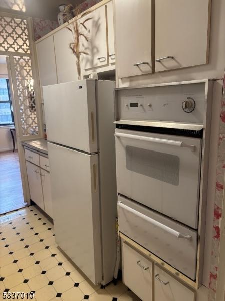 kitchen with white cabinetry and white fridge