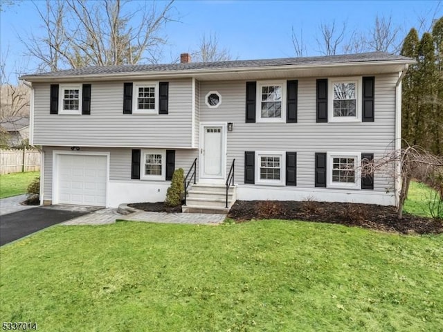 bi-level home with a garage and a front yard