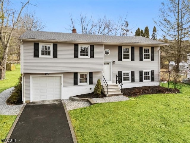 split foyer home featuring a garage and a front yard