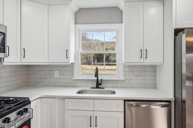 kitchen featuring white cabinetry, sink, tasteful backsplash, and appliances with stainless steel finishes