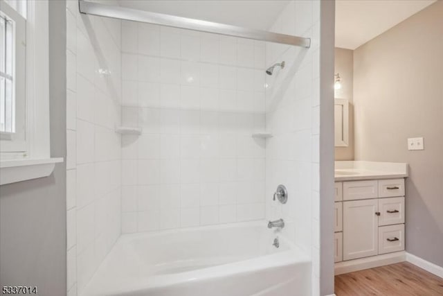 bathroom with vanity, hardwood / wood-style floors, and tiled shower / bath combo