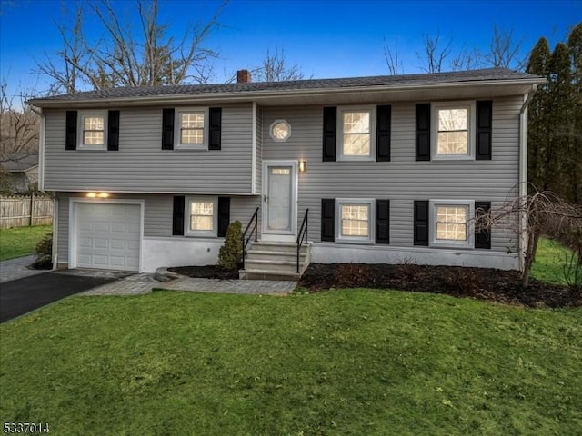 bi-level home with a garage and a front yard