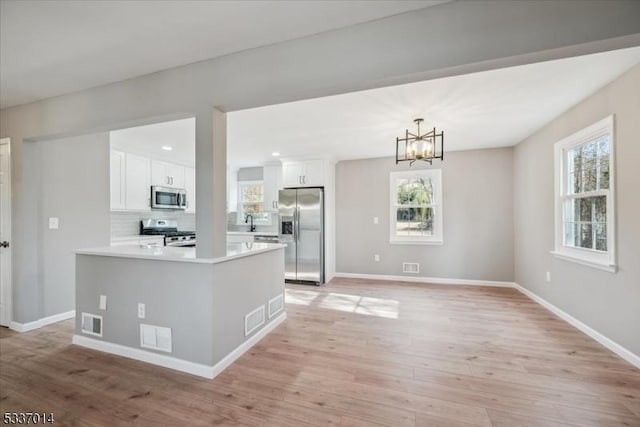 kitchen featuring white cabinetry, light hardwood / wood-style floors, and appliances with stainless steel finishes