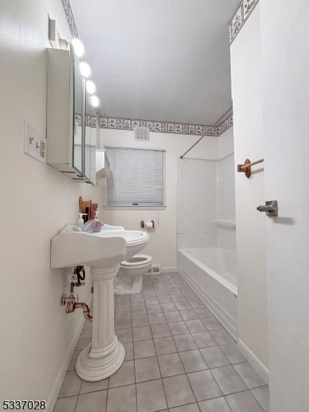 bathroom with tile patterned floors, shower / washtub combination, and toilet