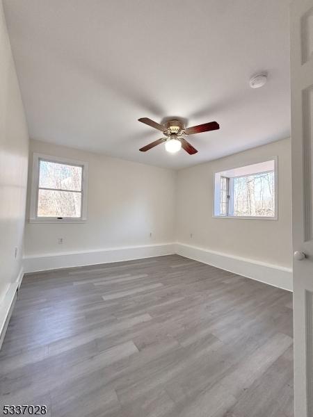 empty room with wood-type flooring and ceiling fan