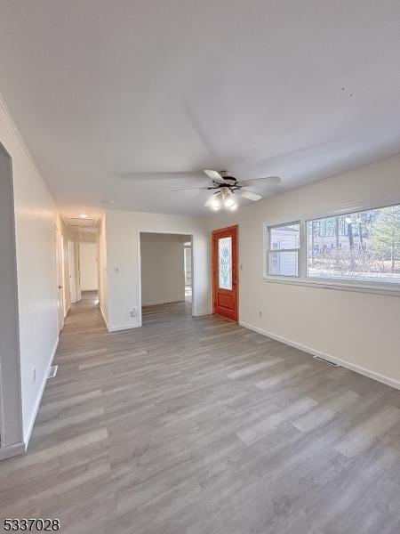 unfurnished living room featuring plenty of natural light, light hardwood / wood-style floors, and ceiling fan