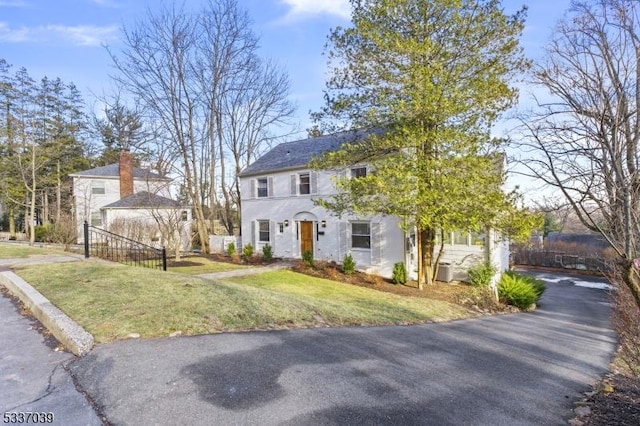 view of front of home with cooling unit and a front lawn