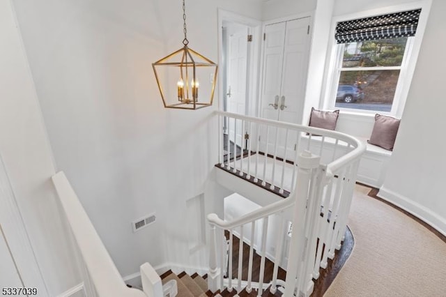 stairs with a notable chandelier