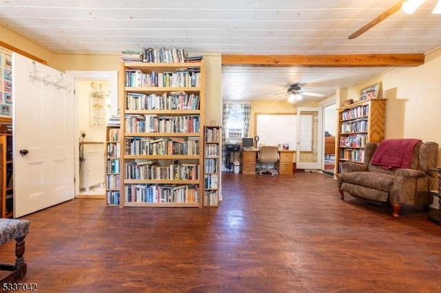 living area with ceiling fan, wood finished floors, and beamed ceiling