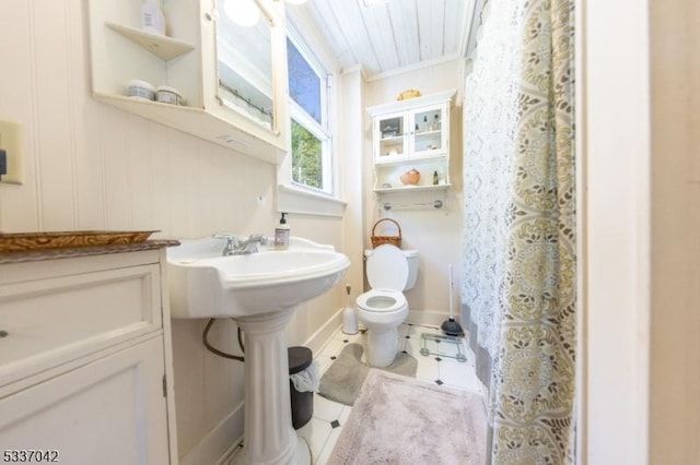 full bathroom featuring toilet, tile patterned flooring, crown molding, and a shower with shower curtain