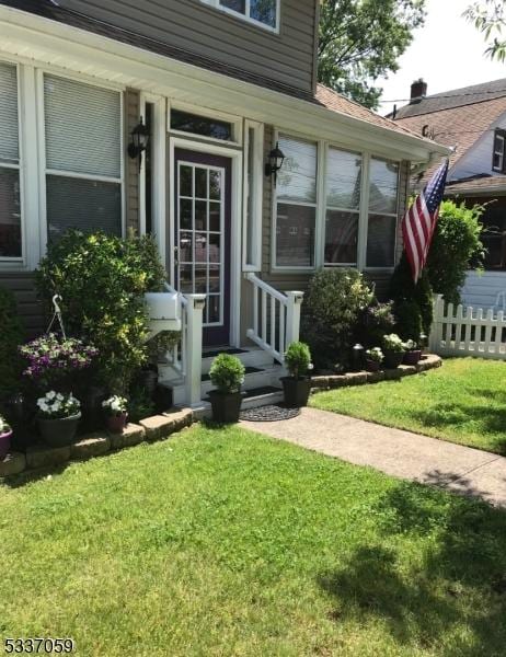 entrance to property featuring a lawn