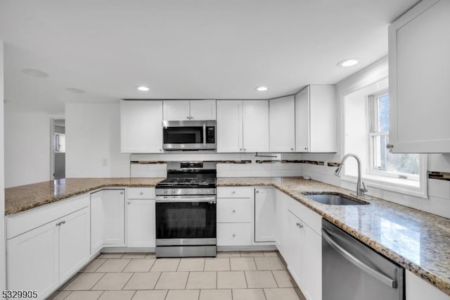 kitchen featuring white cabinetry, sink, stainless steel appliances, and light stone countertops