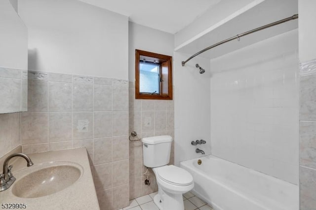 full bathroom with sink, bathing tub / shower combination, tile patterned flooring, tile walls, and toilet