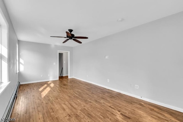 empty room featuring hardwood / wood-style floors, a baseboard radiator, and ceiling fan