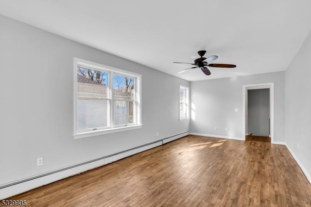 empty room featuring hardwood / wood-style floors, a baseboard radiator, and ceiling fan