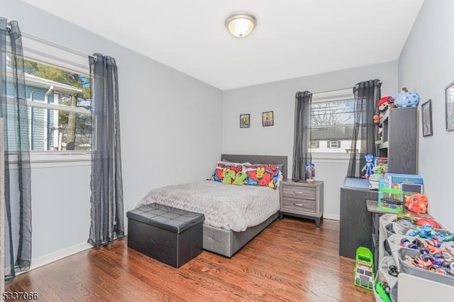 bedroom featuring multiple windows and dark hardwood / wood-style floors