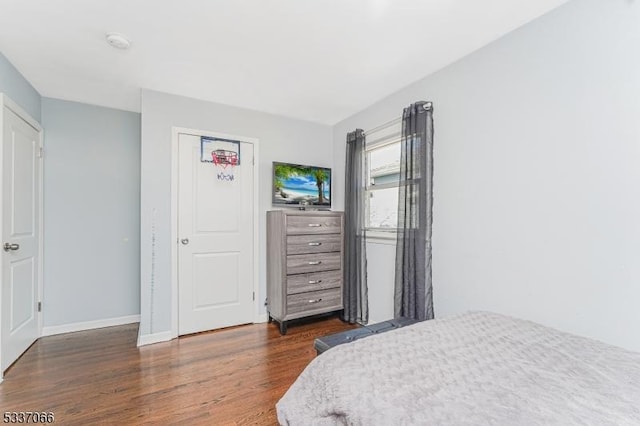 bedroom with dark hardwood / wood-style flooring