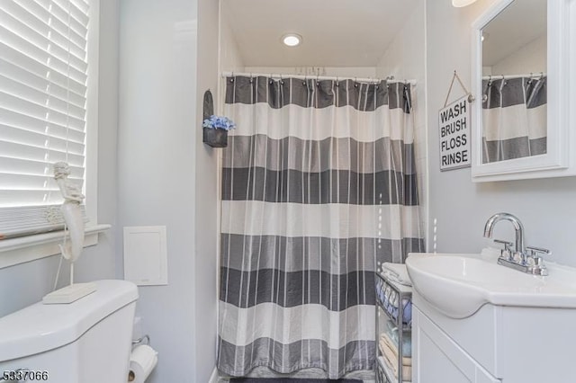 bathroom with vanity, toilet, and walk in shower