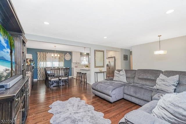 living room featuring a notable chandelier and dark hardwood / wood-style floors