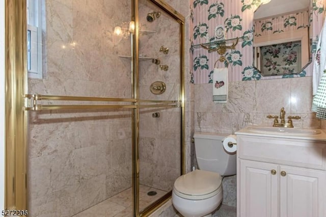 bathroom featuring an enclosed shower, vanity, tile walls, and toilet