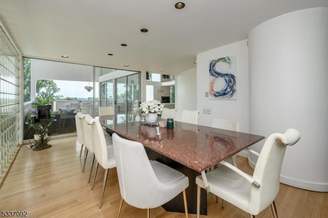 dining area featuring light hardwood / wood-style flooring and a wall of windows