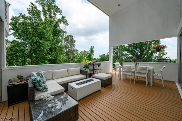 deck with an outdoor living space with a fire pit