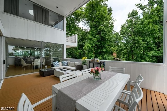 wooden terrace with an outdoor living space with a fire pit