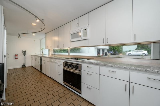 kitchen featuring white cabinetry, black electric cooktop, oven, and light stone counters