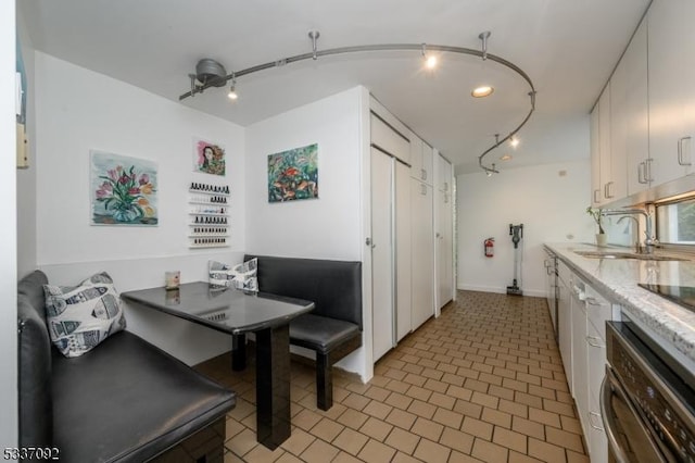 dining room featuring sink, track lighting, and breakfast area