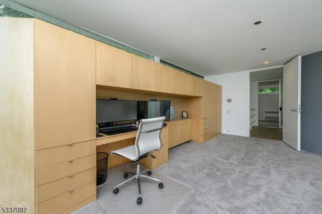 carpeted office space featuring built in desk