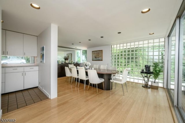 dining area featuring a wall of windows and light wood-type flooring