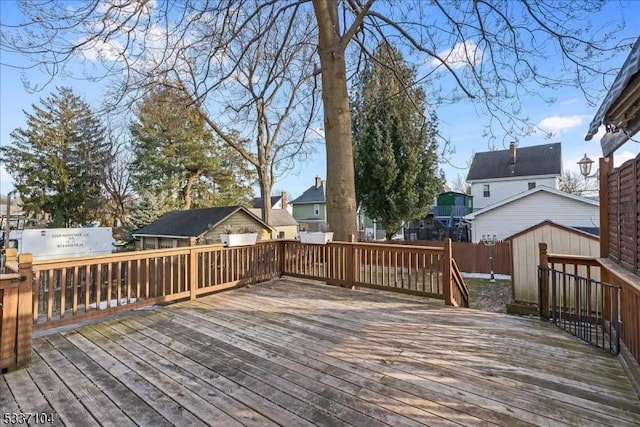 deck with a shed, fence, and an outdoor structure