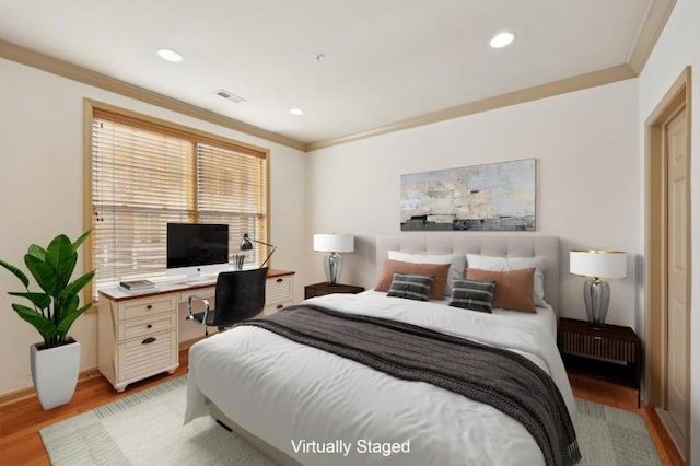 bedroom with crown molding and light hardwood / wood-style floors