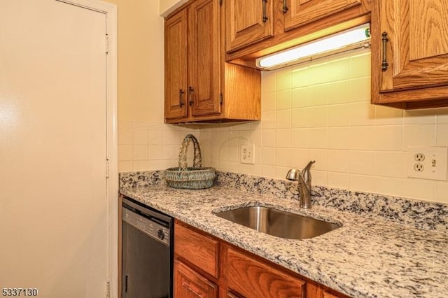 kitchen with dishwasher, sink, light stone counters, and decorative backsplash