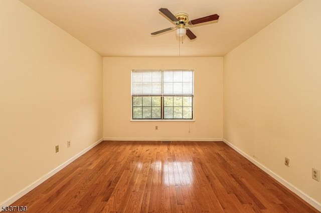 spare room with hardwood / wood-style flooring and ceiling fan